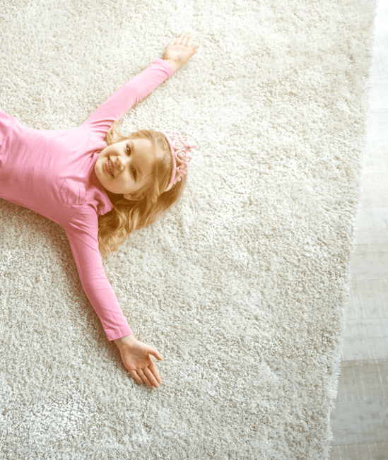 Cute girl laying on rug |  Mid-Michigan Floor Coverings