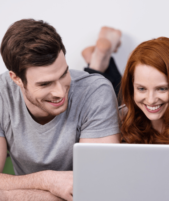 Happy couple with laptop |  Mid-Michigan Floor Coverings